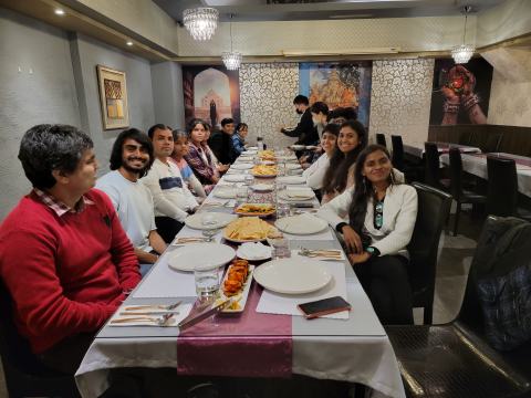 Lab members at a long dinner table in a restaurant.