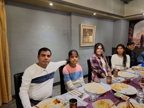 Lab members smiling at the dinner table.