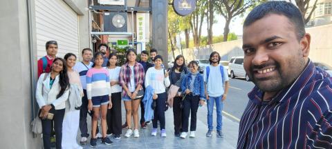 Group photo of lab members on a street, with a selfie in the foreground.