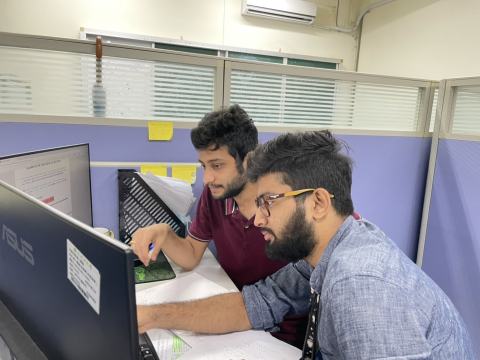 Two lab members looking at a screen together.