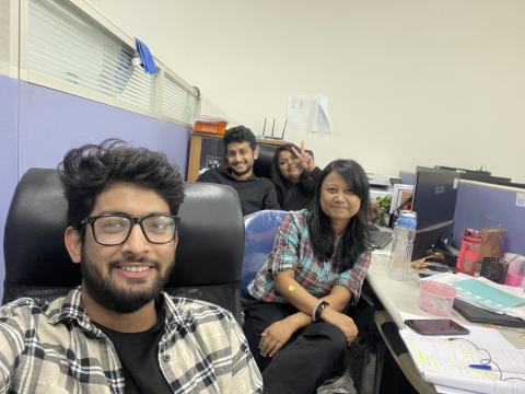 Lab members smiling at their desks.