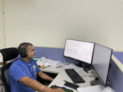 A lab member working at a workstation with two monitors.